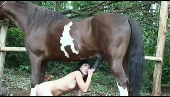 Naked skinny woman sucks a horse on a ranch